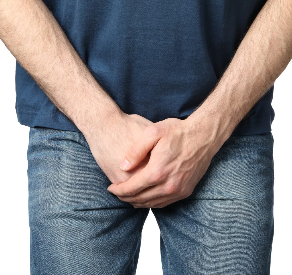 Man holds his crotch, isolated on white background